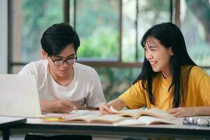 un asiático estudiantes son leyendo libros y estudiar, tutoría juntos. foto