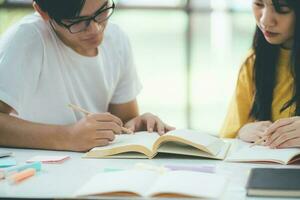 Close up an asian students are reading books and study, Tutoring together. photo