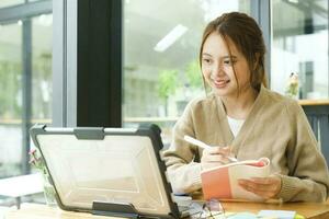 Young female college student uses a computer to access the Internet for online learning. photo