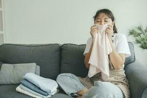 Woman on sofa smell clean luandry at home. photo