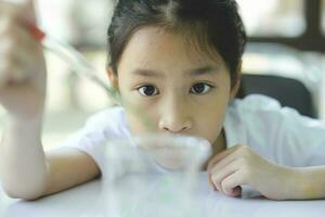 Little child with learning science class in school laboratory photo