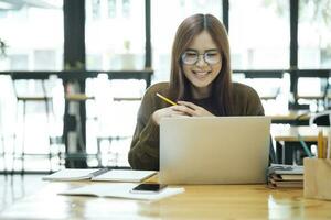Young collage student using computer and mobile device studying online. photo