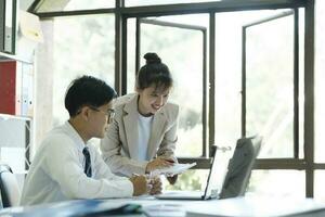 Businesspeople are working by discuss and analyses their project by using laptop and calculator. photo