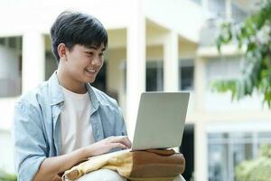 Young collage student using computer and mobile device studying online. photo