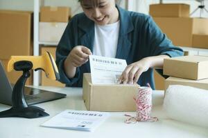 Young entrepreneur packing online order product for shipping. photo