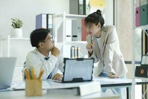 Businesspeople are working by discuss and analyses their project by using laptop and calculator. photo