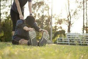 joven hombre y mujer extensión en el parque. foto