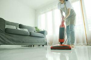 Young woman cleaning house with vacuum cleaner. photo