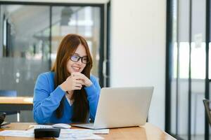 A female college student uses a computer to access the Internet for online learning. photo