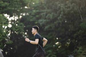 Athletic young man running in the nature. photo