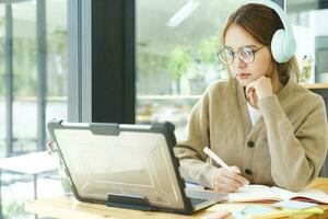 Young female college student uses a computer to access the Internet for online learning. photo