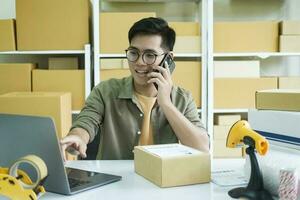 Young online business owner talking with customer on the phone. photo