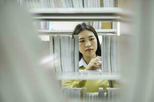 Student choosing and reading book at library. photo