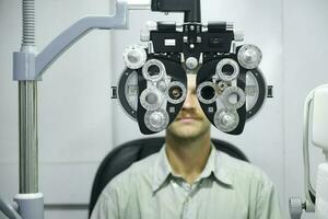 Man having eye test using phoropter. photo
