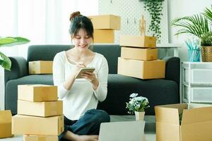 Online small business owner writing address on parcel box. photo