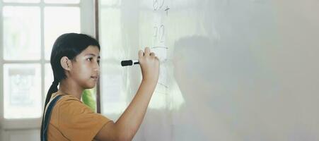 colegio niño pensando mientras haciendo matemáticas problema foto