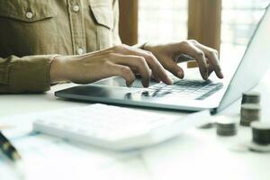 Woman accountant working on laptop computer while counting taxes online. photo