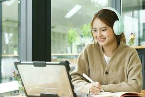 Young female college student uses a computer to access the Internet for online learning. photo