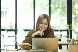Young collage student using computer and mobile device studying online. photo