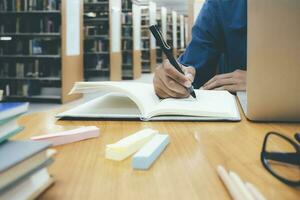 Close up hands with pen writing on notebook. photo