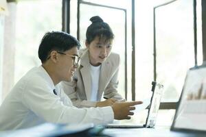 Businesspeople are working by discuss and analyses their project by using laptop and calculator. photo