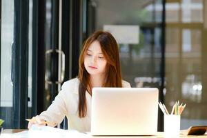 mujer de negocios es trabajando a oficina y utilizando ordenador portátil. foto