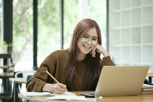 Young collage student using computer and mobile device studying online. photo