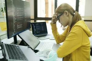 Young woman covering her face with the stress of work coding and programming software. photo