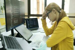 joven mujer cubierta su cara con el estrés de trabajo codificación y programación software. foto