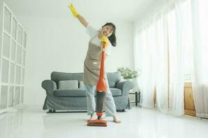 joven mujer teniendo divertido mientras limpieza hogar. foto