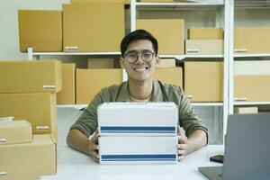 joven masculino en línea negocio propietario trabajando y mirando a cámara. foto