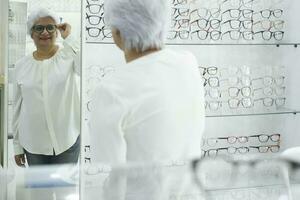 Woman trying new eyeglasses frame. photo