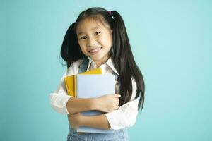 Close-up kid students girl smiling holding book, going to school. photo