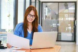 A female college student uses a computer to access the Internet for online learning. photo