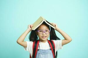 niño estudiantes yendo a escuela, niña gracioso sonriente, niño estudiantes niña con lentes sostener libros en su cabeza. foto