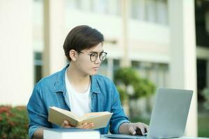 estudiante estudiando al aire libre utilizando ordenador portátil. foto