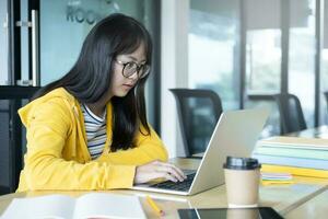 Young collage student using computer and mobile device studying online. photo