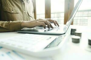 Woman accountant working on laptop computer while counting taxes online. photo