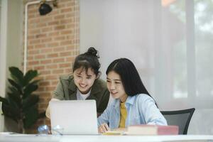 Young asian university students studying learning discuss working on computer. photo