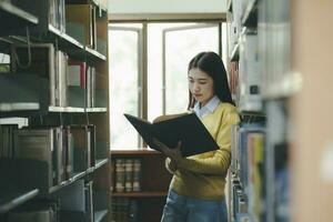 estudiante en pie y leyendo libro a biblioteca. foto