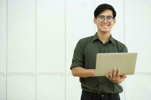 Young asian business man or student working online on computer laptop. photo