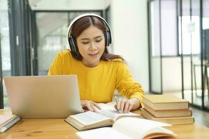 Young collage student using computer and mobile device studying online. photo