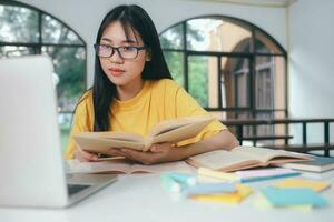 Young Asian female student is preparing to reading a books for exams at university. photo