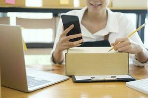 Female online business owner checking order using cellphone. photo