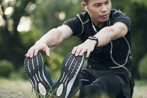 Athletic man in black sportswear doing fitness stretching exercises. photo