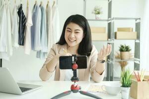 Businesswoman giving important pieces of advice while streaming video for women's clothing. photo