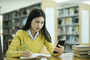 Student studying at library using phone. photo