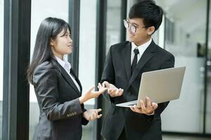 Two businesspeople talking and discussing while standing. photo