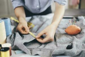 The tailor taking measurements of jacket photo