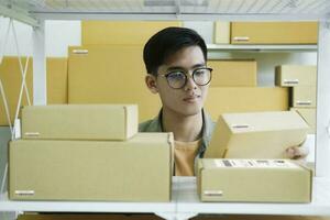 Online store owner checking orders for packaged product. photo